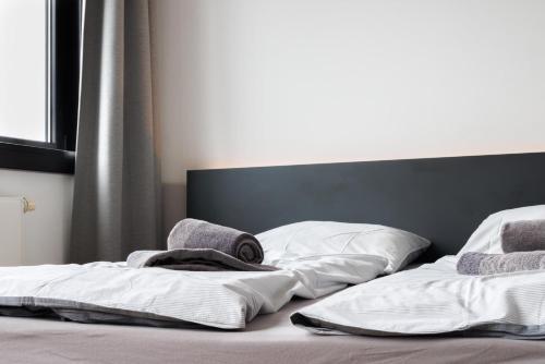 a bed with two pillows and towels on it at Glück Auf Appartements Düppelstraße in Oberhausen