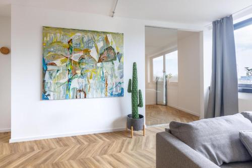 a living room with a cactus and a painting on the wall at Glück Auf Appartements Düppelstraße in Oberhausen
