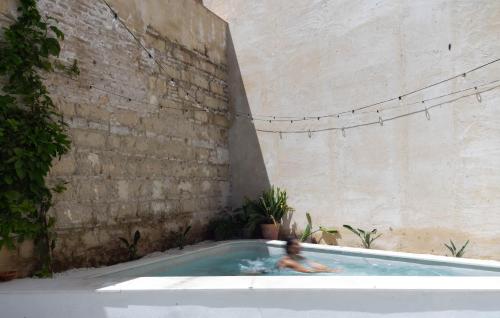 a person in a swimming pool next to a brick wall at La Bodega Flamenca in Jerez de la Frontera