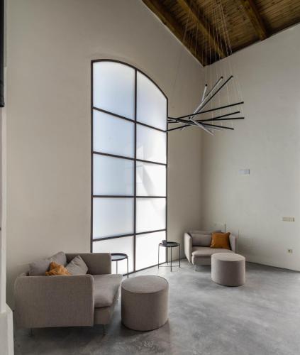 a living room with couches and tables and a large window at La Bodega Flamenca in Jerez de la Frontera