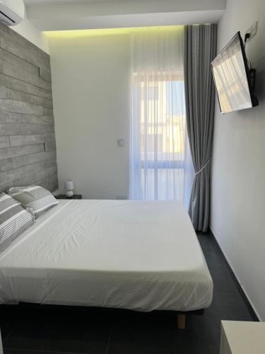 Un dormitorio con una cama grande y una ventana en Cosy & Modern Top Floor 1-bedroom Apartment, en St Paul's Bay