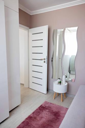 a bathroom with a mirror and a pink wall at Joyful apartment in Timişoara
