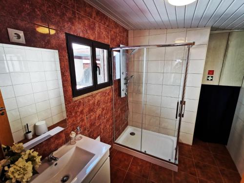 y baño con ducha y lavamanos. en Saborearia Guesthouse, en Figueira de Castelo Rodrigo
