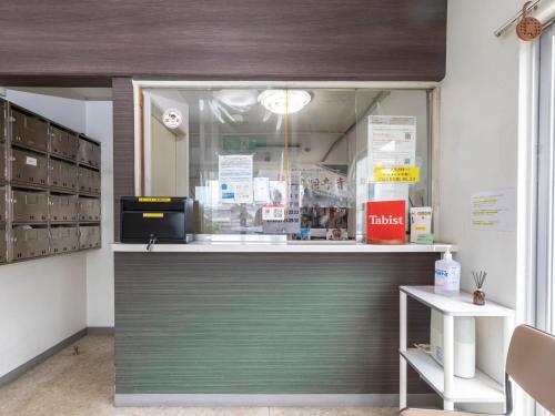 a store counter with a green door in a store at Tabist Motodai Business Hotel Kanonji in Kanonji