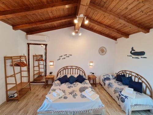 1 dormitorio con 2 camas y techo de madera en Montilisciu Cottage, en San Teodoro