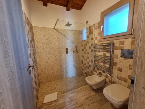 y baño con ducha, aseo y lavamanos. en Montilisciu Cottage, en San Teodoro