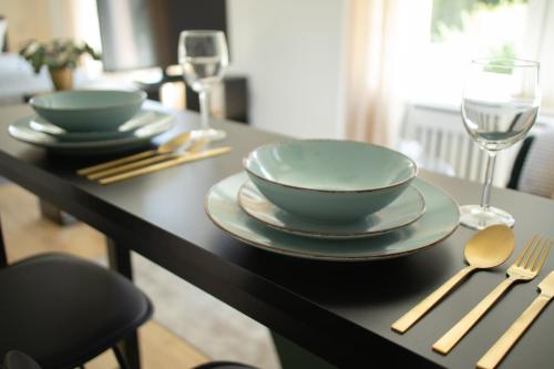 a table with two bowls and plates and wine glasses at Löwe Apartment Gold Tiengen Altstadt in Waldshut-Tiengen