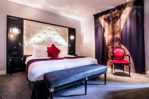 a bedroom with a large bed and a red chair at Maison Albar - Le Diamond in Paris