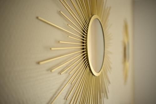 un orologio d'oro con uno specchio su un muro di Löwe Apartment Gold Tiengen Altstadt a Waldshut-Tiengen