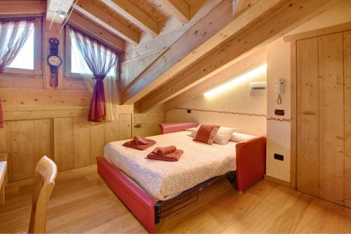 een slaapkamer met een bed in een houten huis bij Baita dei ski app 5 in Livigno