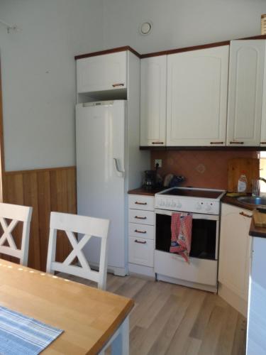a kitchen with white cabinets and a white stove top oven at Walhalla apartment in Forssa