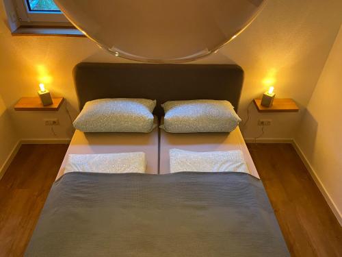 Dormitorio pequeño con 2 camas y 2 luces en Ferienwohnung im Chalet Scheibenberg, en Scheibenberg