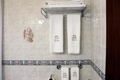 a bathroom with white towels hanging on a wall at Hotel Vale Do Côa in Vila Nova de Foz Coa