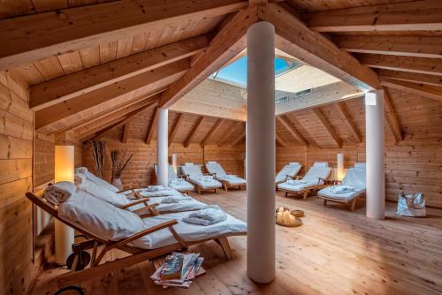 a room in a wooden house with white furniture at Hotel Bad Salomonsbrunn in Anterselva di Mezzo