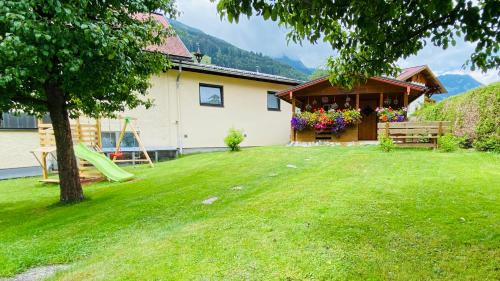 a house with a yard with a slide at Wengerhof "Urlaub im Gasteinertal" in Dorfgastein
