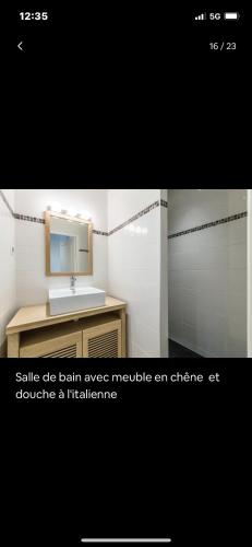 une salle de bain avec un lavabo et un miroir dans l'établissement appartement t3 avec patio à 300m de la plage, à Biarritz