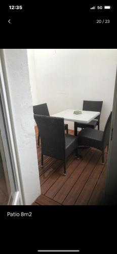 une table et des chaises assises sur une terrasse en bois dans l'établissement appartement t3 avec patio à 300m de la plage, à Biarritz