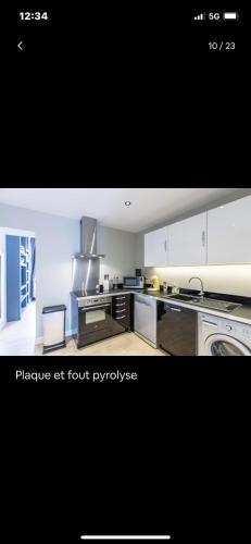 une grande cuisine avec des armoires et des appareils blancs dans l'établissement appartement t3 avec patio à 300m de la plage, à Biarritz