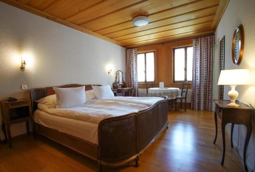 a bedroom with a large bed in a room with wooden ceilings at La Fleur de Lys in Gruyères