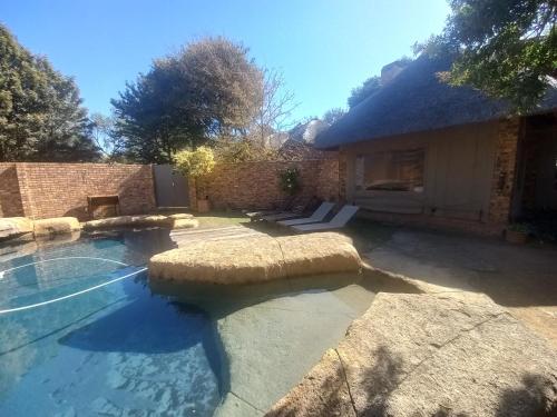 une piscine dans une cour avec une maison dans l'établissement Khaya Africa Guesthouse, à Midrand