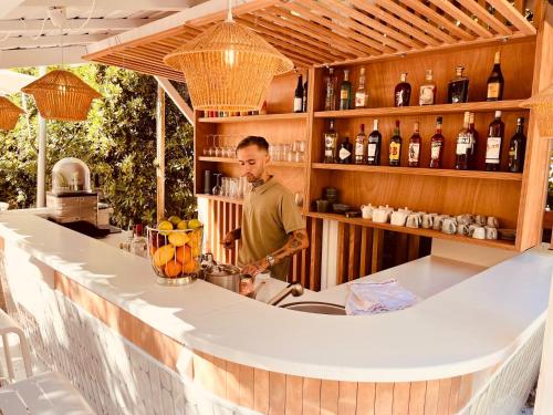 a man standing behind a counter in a bar at Hôtel De Londres in Menton