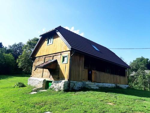 a large wooden barn on a grass field at Bakina iža in Duga Resa