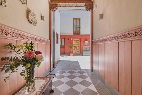 um corredor com um vaso de flores sobre uma mesa em Casa de La Tiña em Granada