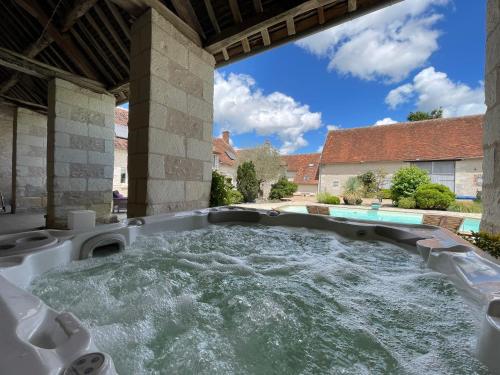 una vasca idromassaggio in un cortile con acqua di Chambres d'hôtes L'Escale Charmante a Choussy