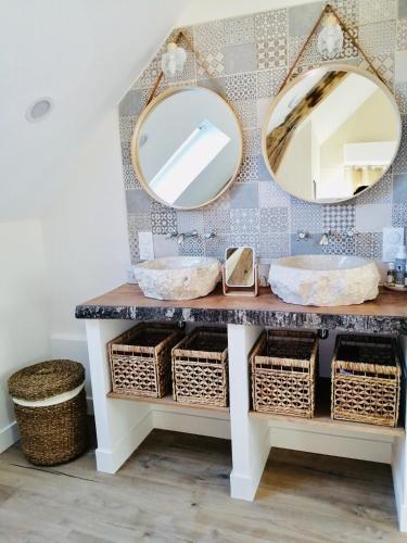 a bathroom with a vanity with two mirrors and baskets at Chambres d'hôtes L'Escale Charmante in Choussy