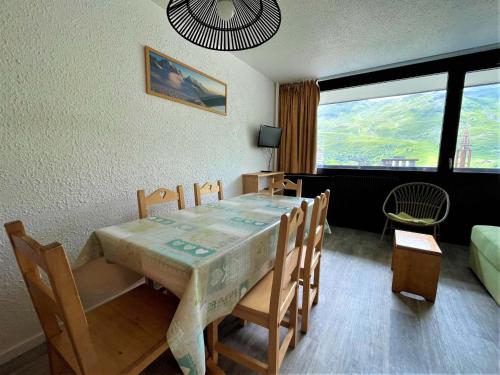 une salle à manger avec une table et des chaises et un salon dans l'établissement Appartement pour 6 pers, 38m², balcon sud, au pied des pistes, Les Menuires Croisette - FR-1-452-179, aux Menuires