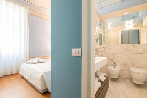 y baño con cama, aseo y lavamanos. en La Suite del Borghetto, en Pisa