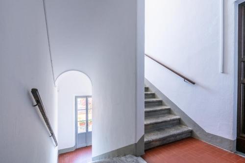 a staircase in a building with white walls and red floors at La Suite del Borghetto in Pisa