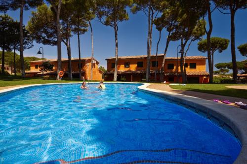 two people swimming in a large blue swimming pool at Casas Golf Relax in Pals