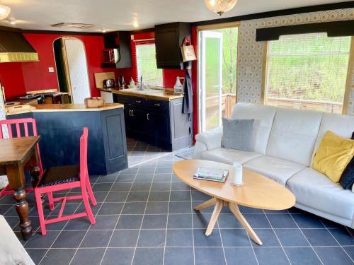 a living room with a white couch and a table at The Good Life Wales with Hot tubs in Llywel