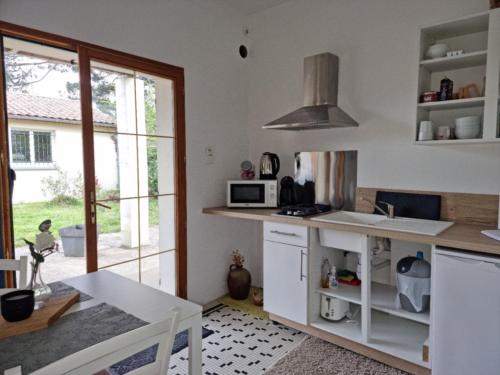 a kitchen with a white counter and a microwave at Appartement KEYSTONE BIBA in Libourne