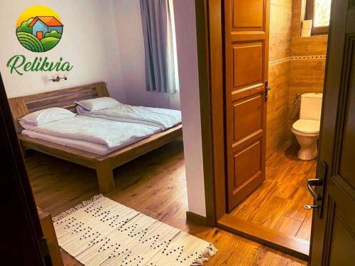 a small bedroom with a bed and a toilet at Relikvia in Sovata