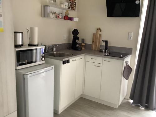 a kitchen with a sink and a microwave at 2 persoons appartement de luxe in Nijverdal
