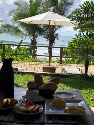 Pousada Pipe House في إيتاكاري: طاولة مع صحن من الطعام ومظلة