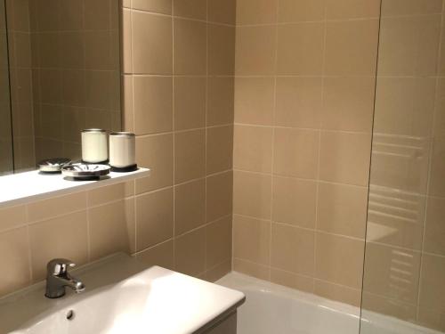 une salle de bain avec une baignoire, un lavabo et un miroir dans l'établissement Appartement rénové 7/8 pers, au calme avec balcon, parking et wifi inclus, au centre de la station - FR-1-346-307, à Arc 1800