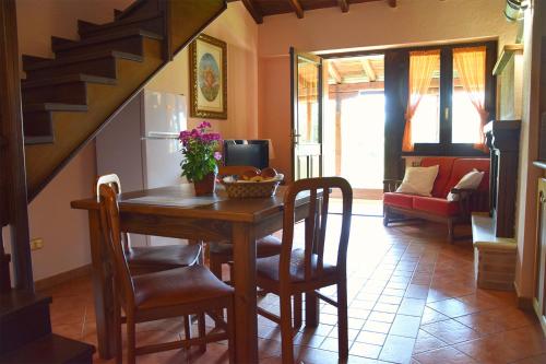 a dining room with a table and chairs and a staircase at Casale Santa Croce in Pastena
