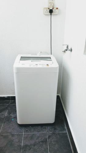 a white washing machine sitting on a floor next to a wall at BSP21 Family Homestay in Jenjarum