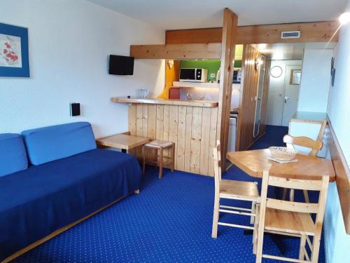 Cette petite chambre comprend un lit, une table et une cuisine. dans l'établissement Studio lumineux au centre, balcon, proche pistes, wifi inclus - FR-1-346-420, à Arc 1800