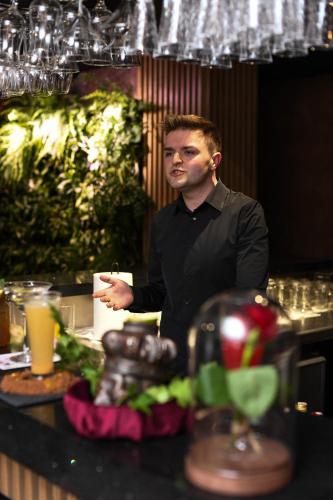 a man standing behind a counter holding a piece of paper at Hotel Jedlinka in Jedlina-Zdrój