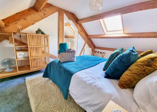 ein Schlafzimmer mit einem großen Bett mit blauen Kissen in der Unterkunft Eldon Row - Stylish Character Apartments - Central Location 1 & 2 bed available in Dolgellau