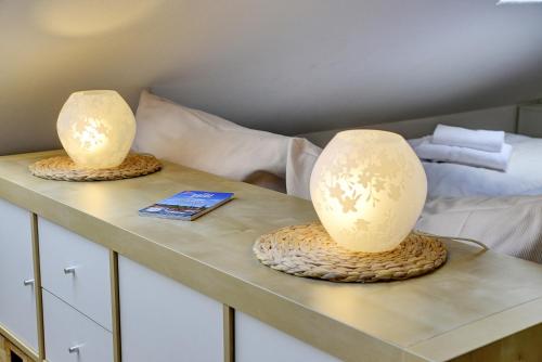 two lamps on a table next to a bed at fewo1846 Strandresidenz Wassersleben - Kleine Meerjungfrau - komfortables Studioapartment im Dachgeschoss in Harrislee