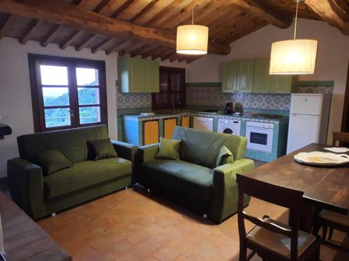 una cocina con 2 sofás y una mesa en una cocina en Casa di campagna in collina, en Tatti