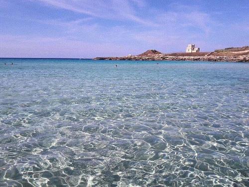 a large body of water with a castle in the background at Residence Sunbeam in Leporano Marina