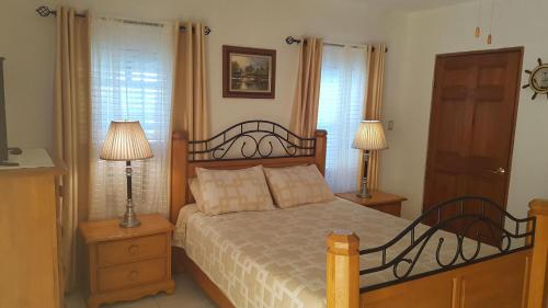 a bedroom with a bed with two lamps and two windows at AIRBAB Moon Gate East in Mount Pleasant