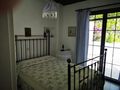 1 dormitorio con cama y ventana grande en Maria's Studios, en Áfissos
