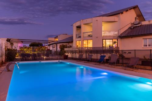 ein Pool vor einem Haus in der Unterkunft The Originals City, Hôtel Les Dômes, Perpignan Sud Saleilles in Perpignan